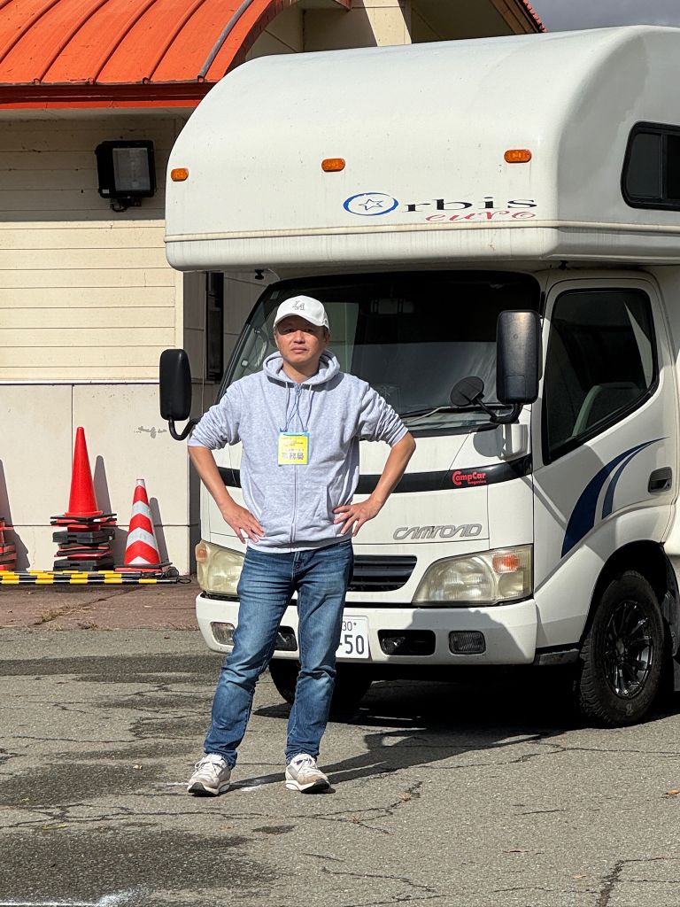 PixelDrive株式会社 代表取締役 山縣麻人 — キャンピングカーの前に立つ代表写真